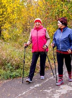 Two Women Pole Walking in the Fall on a Path