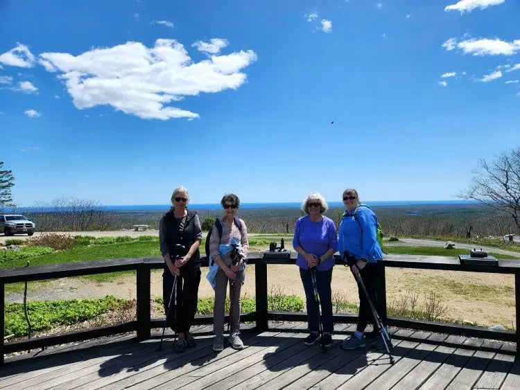 People with walking poles after hiking to the top of a mountain