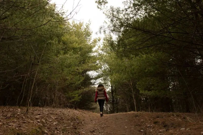 Woman walking through a forest clearing