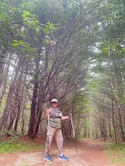 Woman With Walking Poles on a Trail in the Woods