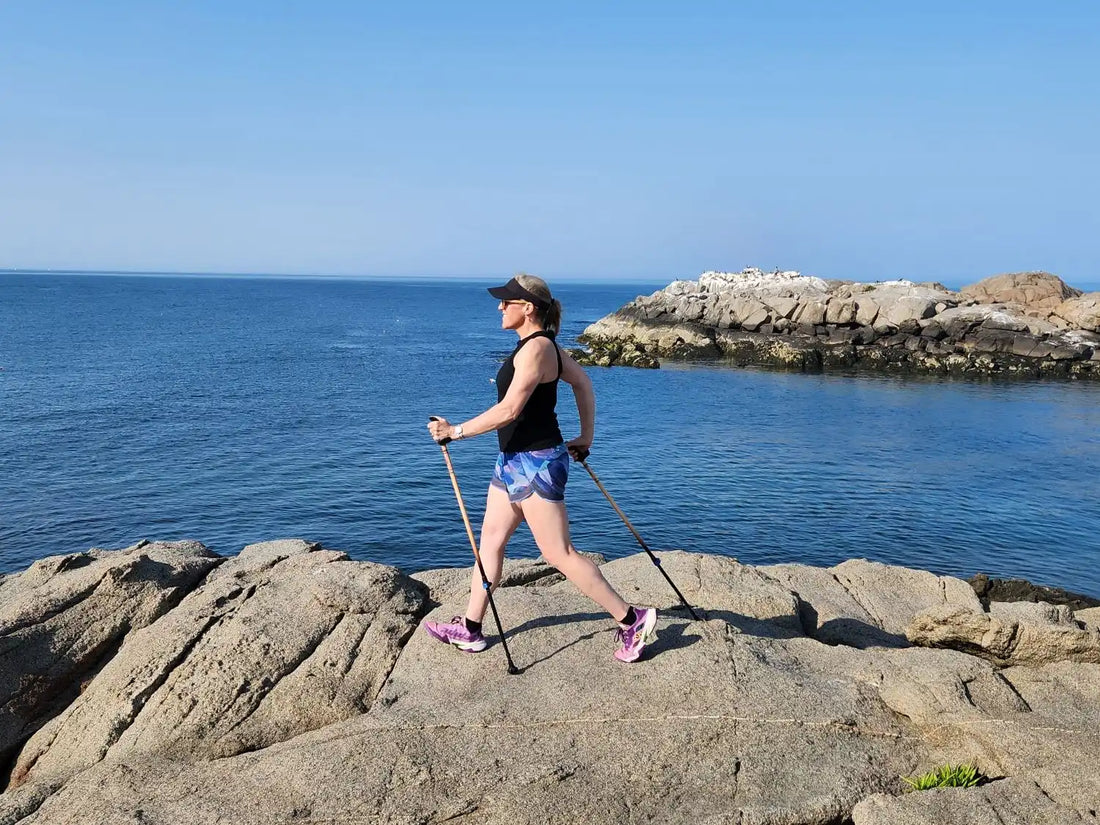 Woman walking on rocks with walking poles